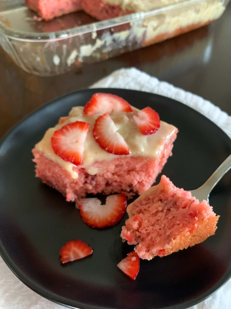 strawberry banana cake on black dessert plate with fork
