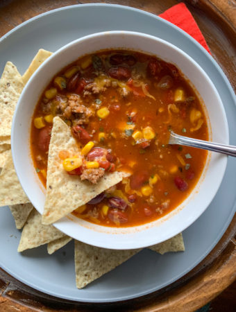 7 can taco soup with ranch dressing mix in white bowl with chips