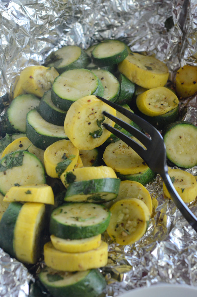 grilled zucchini and squash in foil packets with black fork on top