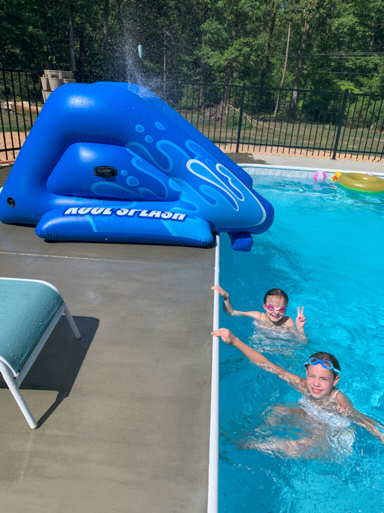two girls in front of an Intex Kool Splash slide at family pool
