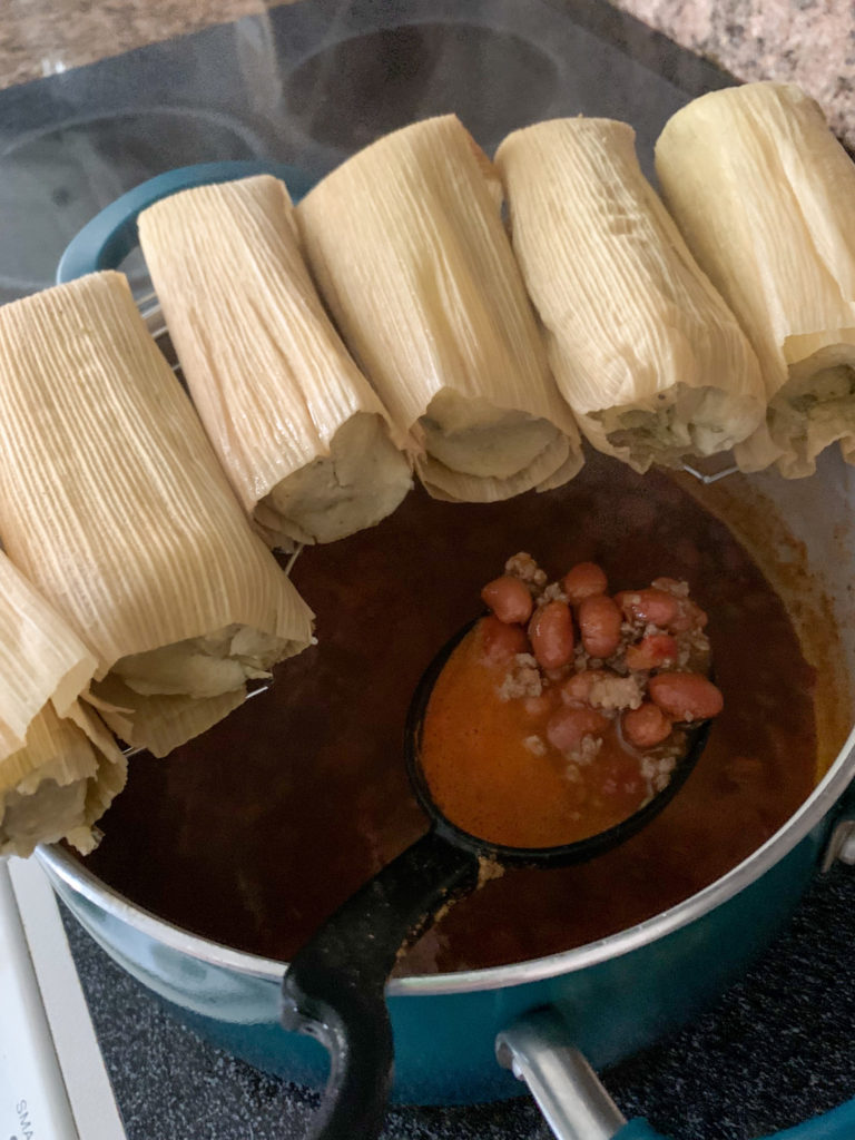 steamer rack of tamales over pot of charro beans chili 