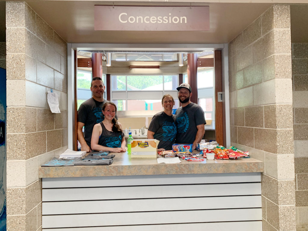 four people standing at concession stand