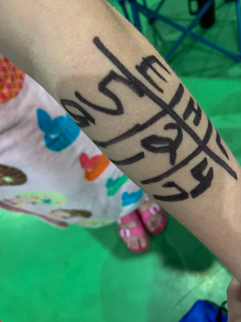 girl with writing on left arm for kids swim meet event 