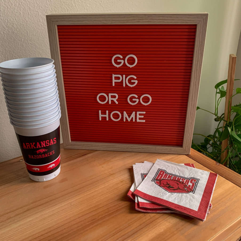 red letter board with Arkansas Razorbacks quotes and cups and napkins