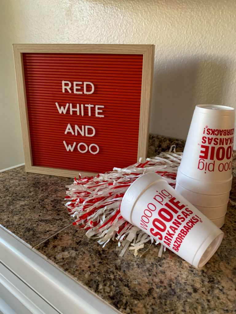 quotes about Arkansas Razorbacks on red letter board with Woo Pig Sooie cups