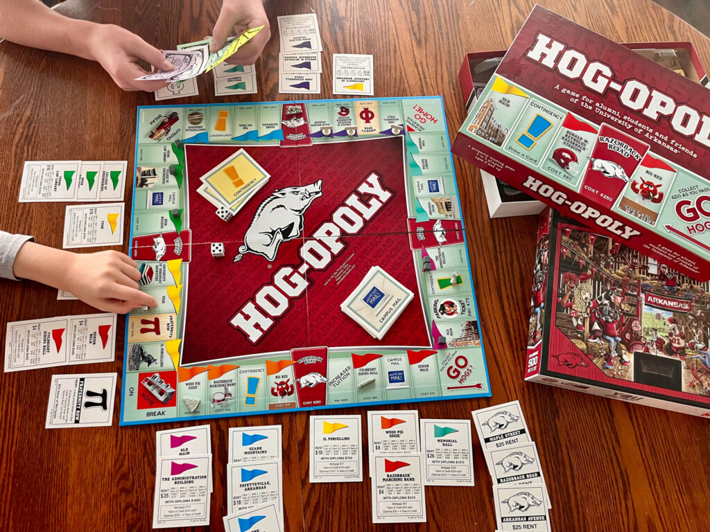 kids playing Arkansas Hog-Opoly on kitchen table for Arkansas Razorback gift ideas