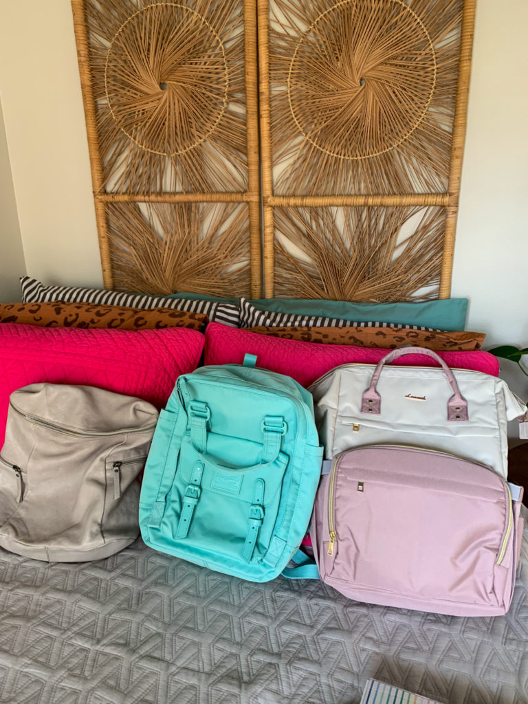 three backpacks for teachers of different styles on bed