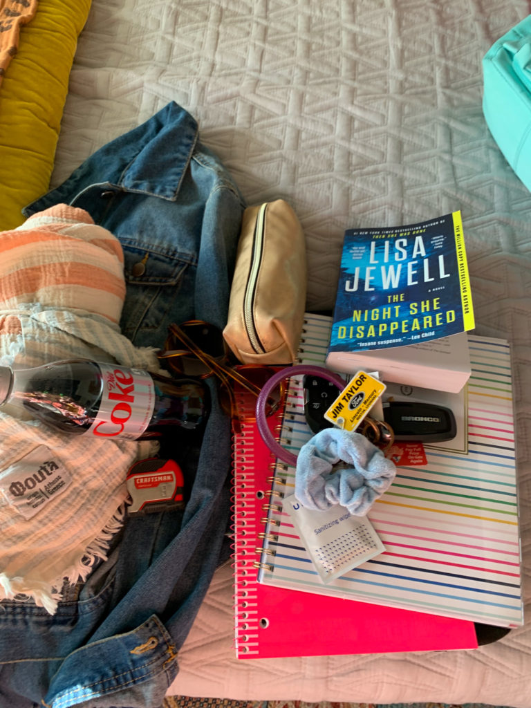 collection of things on bed for carry on backpack for plane travel or backpacks for teachers