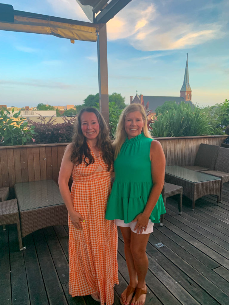 two ladies posing in Charleston outfits on the rooftop bar of Stars
