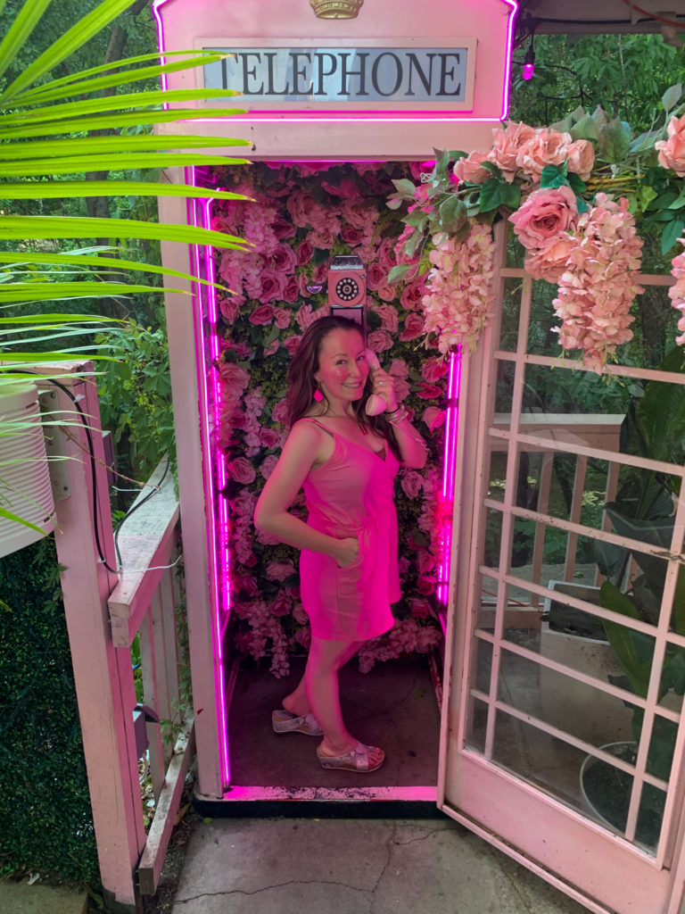woman poses in phone booth at Taquero Mucho