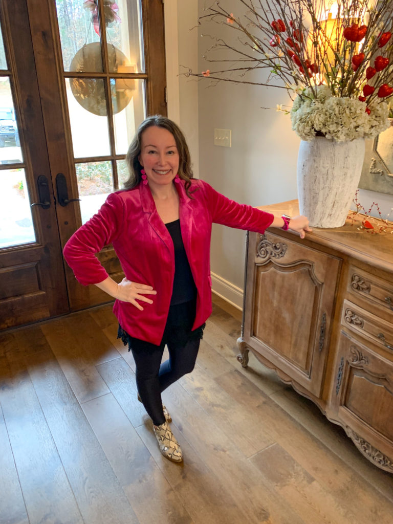 woman wears outfits with blazers - hot pink blazer with black leggings inside foyer of home