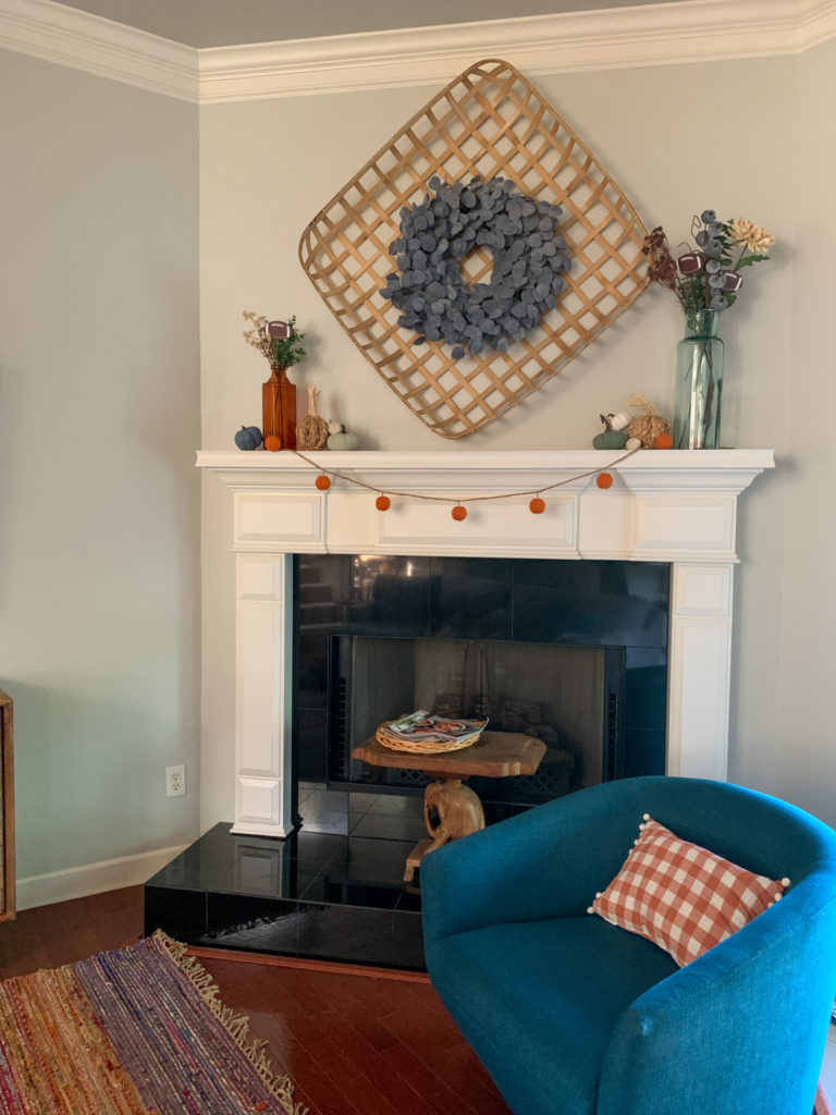 fall football home decor on mantle with orange plaid pillow on chair