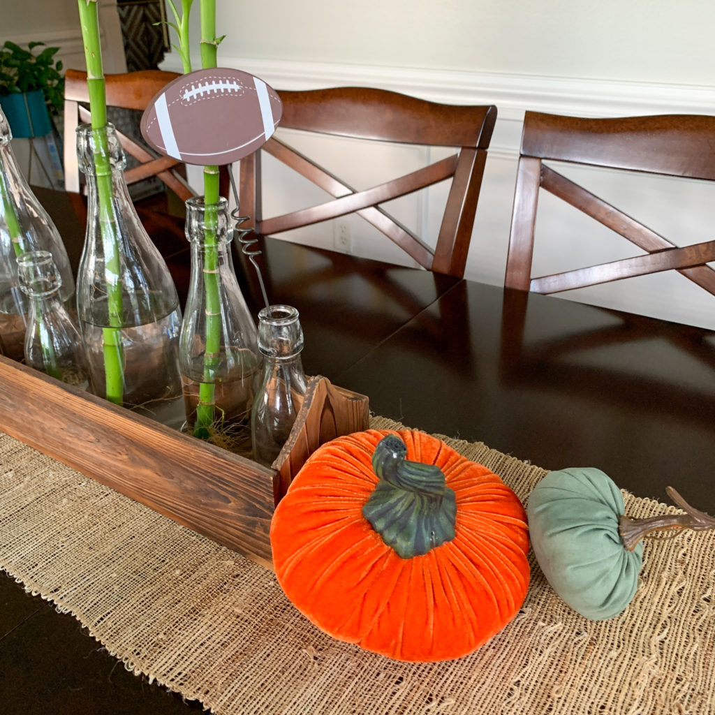fall football tablescape with velvet pumpkins and football picks in bamboo plants vases