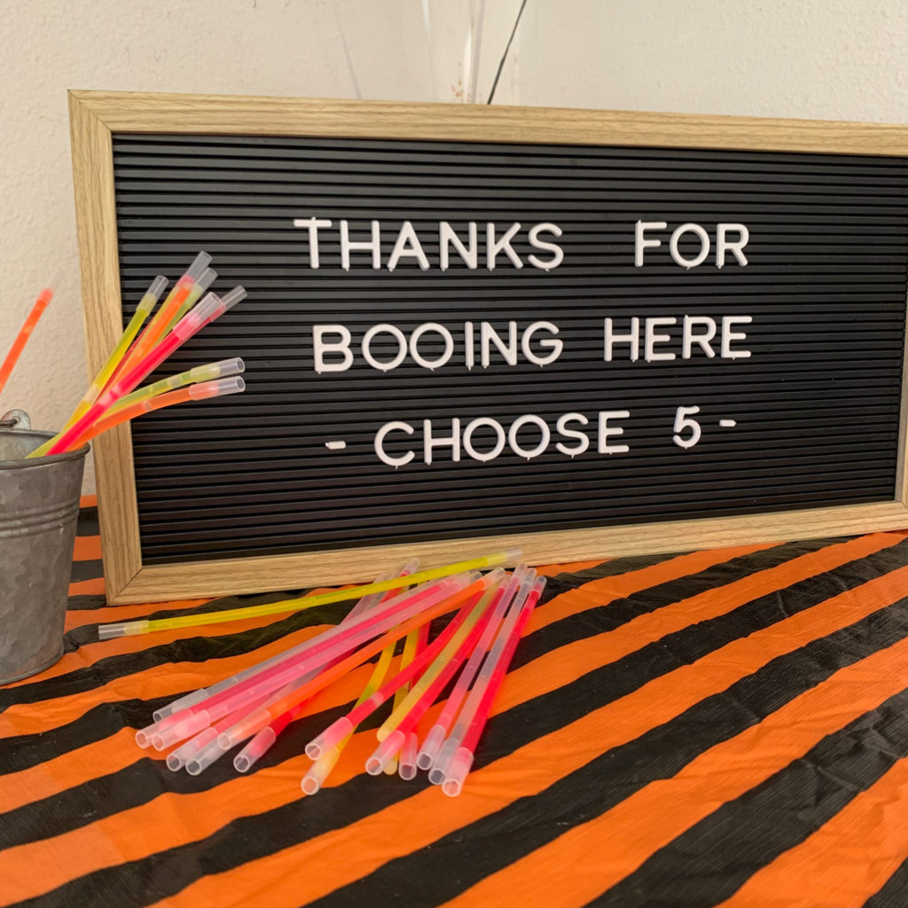 fun sign for kids Halloween party with glow sticks in front