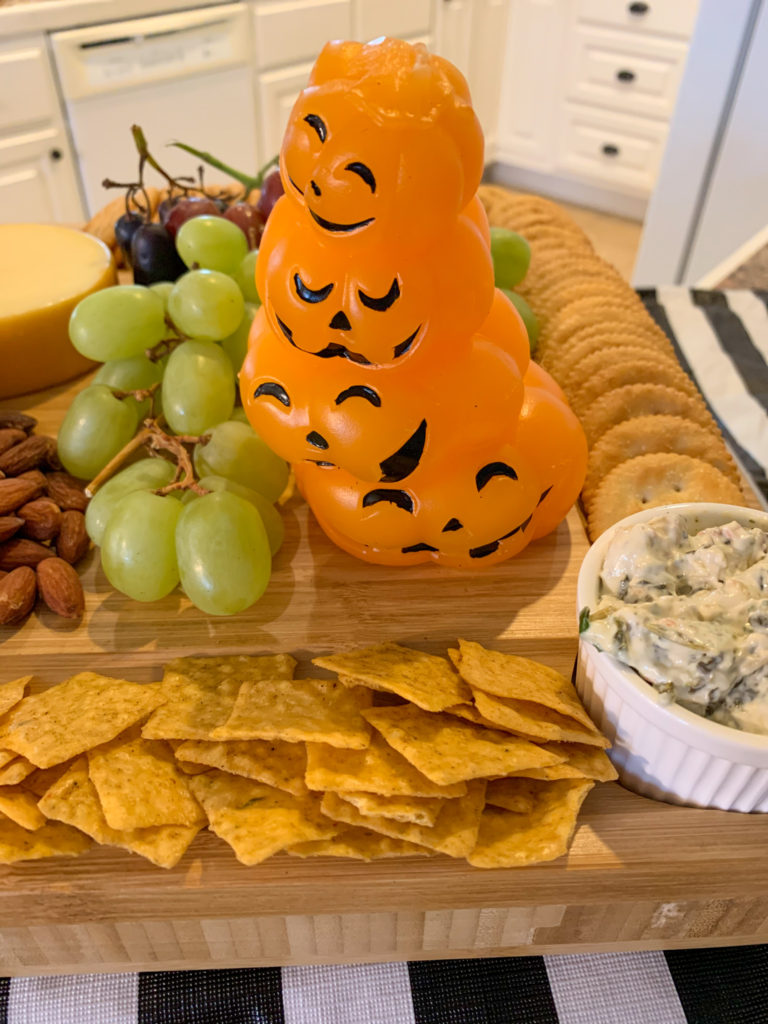 charcuterie board with stack of wax pumpkins