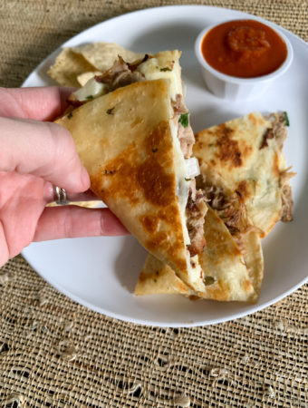 pulled pork quesadillas with leftover pulled pork in woman's hand