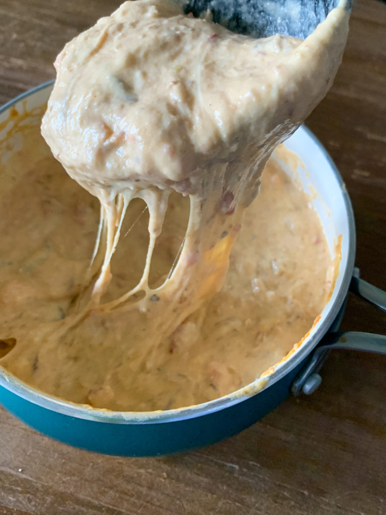 spoonful of spicy queso dip in saucepan