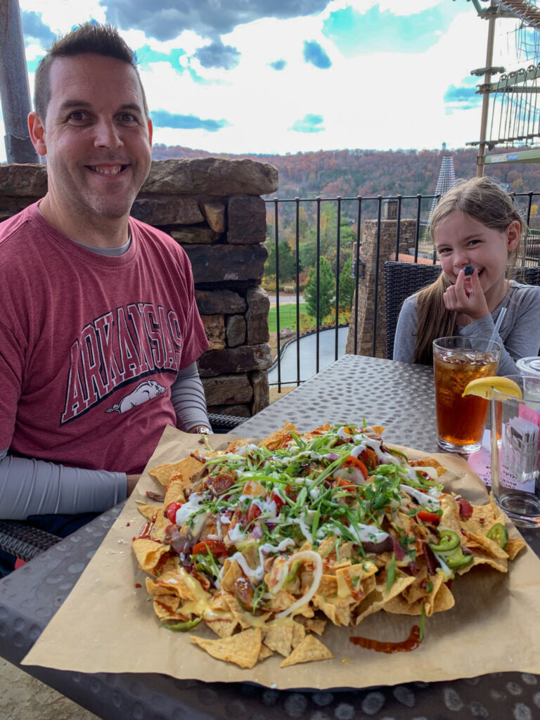 dad and daughter with the nachos from the Uncle Buck's menu