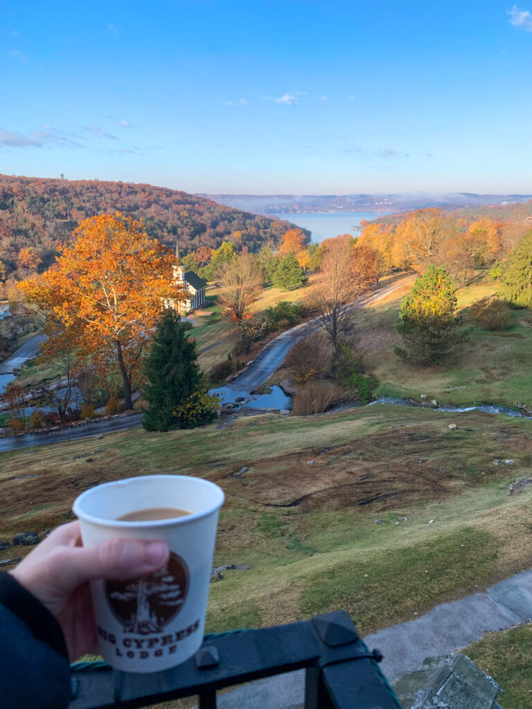 a woman holds a cup of coffee while overlooking the property at Big Cedar Resort