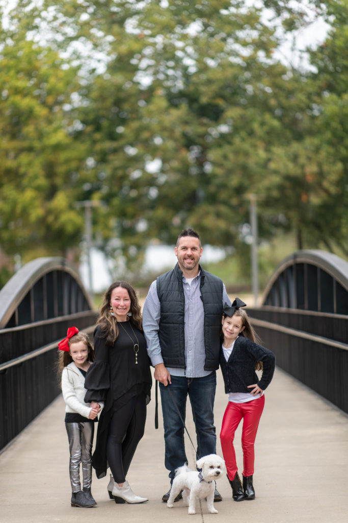 Bryant Arkansas Blogger, Amy, poses with family in faux leather leggings outfits for fall family photos with dog