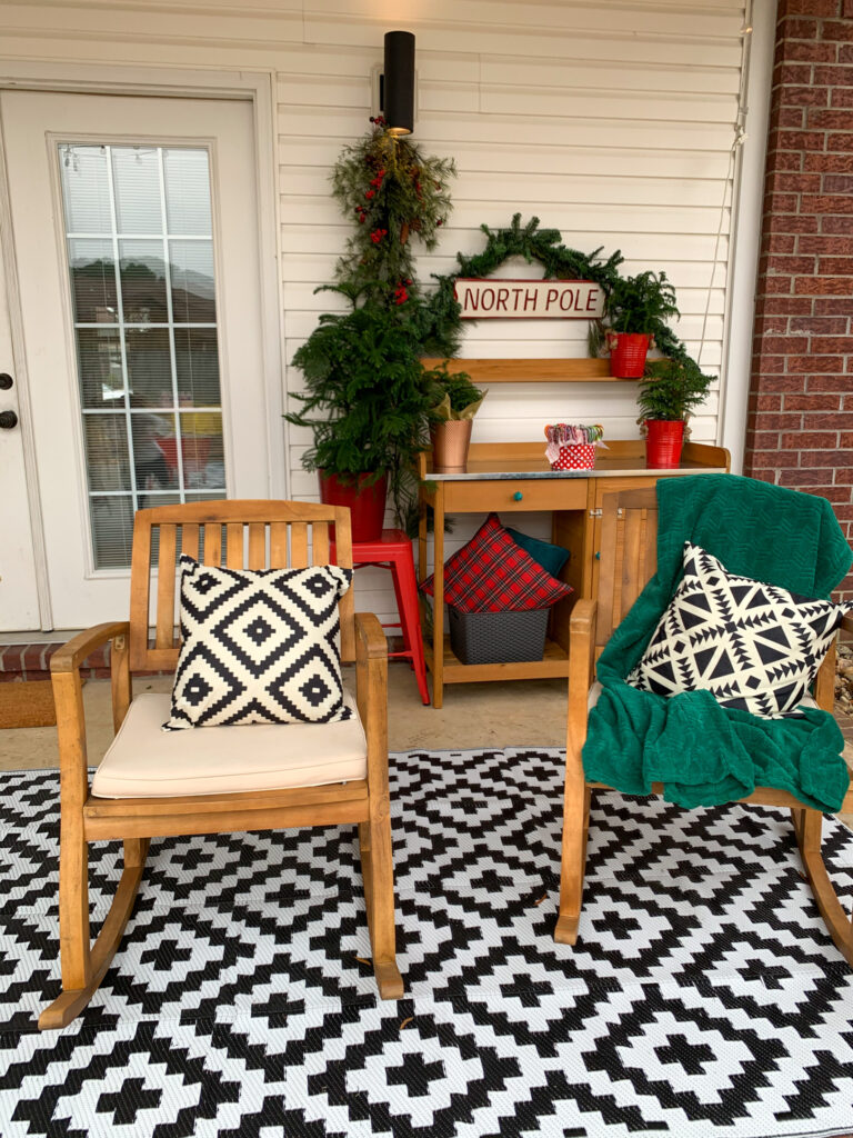 a decorated back porch with a North Pole sign