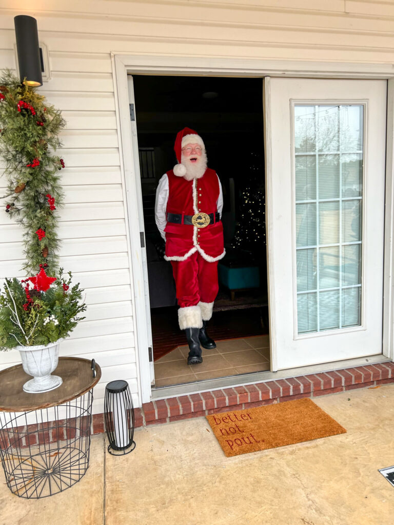 Santa walks onto a back porch during a home Santa visit