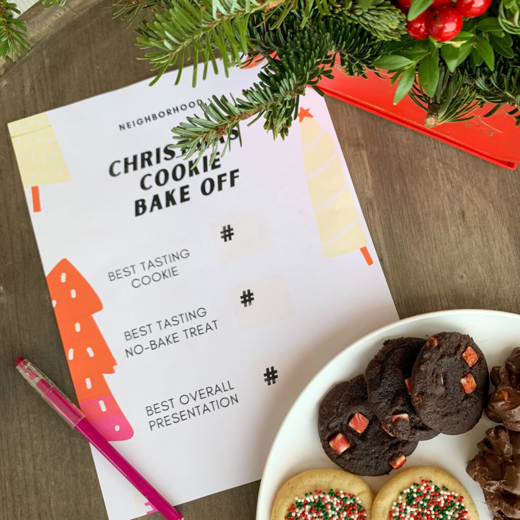 Christmas cookie bake off score sheet on table beside plate of cookies with plant in back