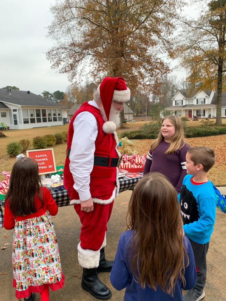 Santa Pete visits with some children at a neighborhood Cookies with Santa event