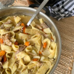 leftover turkey noodles soup in large stainless steel pot
