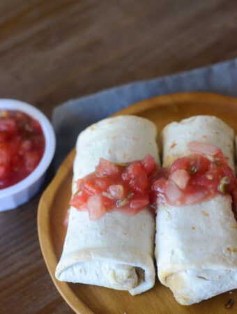 air fryer frozen burritos on a wooden plate with salsa