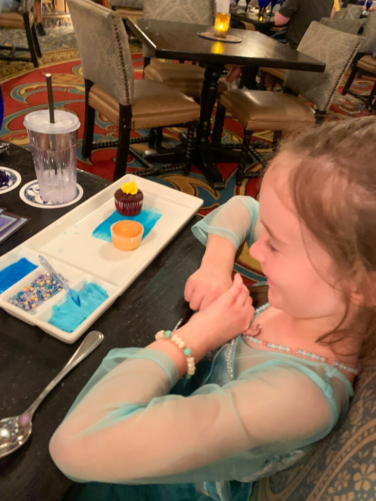 little girl with the make your own cupcake dessert at Cinderella's castle dinner
