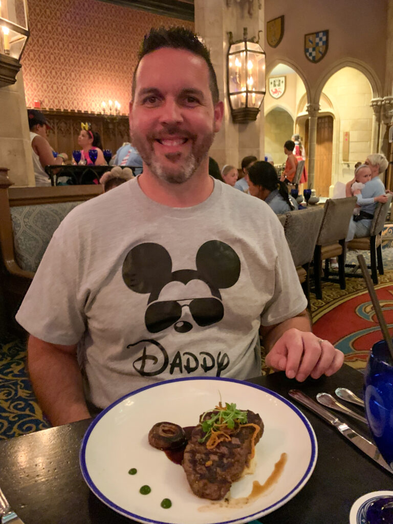 man with Mickey Mouse shirt on at Cinderella's Royal Table dinner