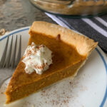 slice of creamy pumpkin pie with condensed milk on white and blue saucer