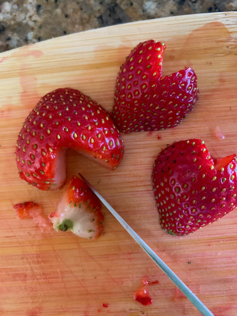 heart shaped strawberries on cutting board with knife