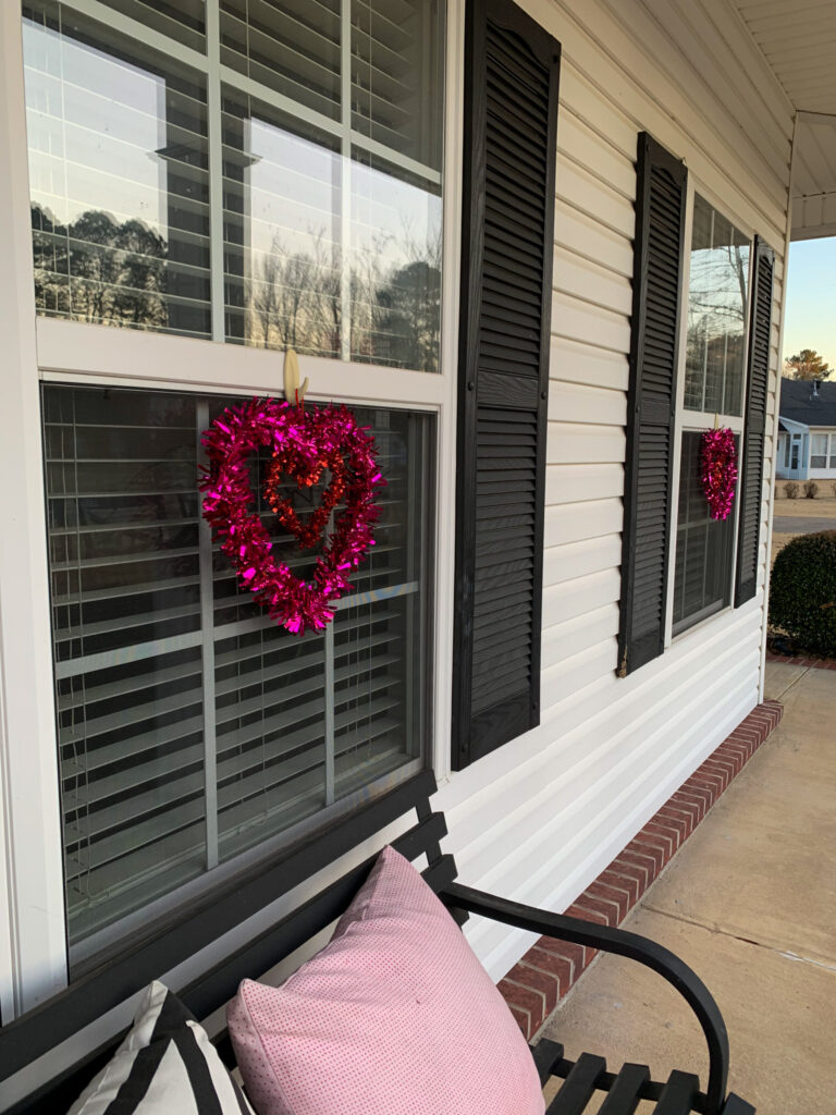 pink tinsel hearts hang as Valentine's Day window decor for Valentine's Day porch ideas
