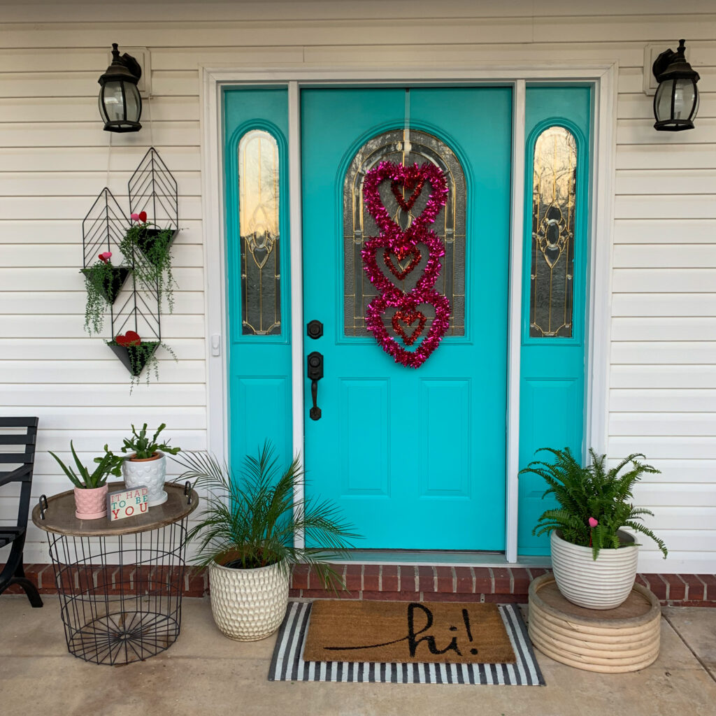 Valentine's Day porch decor on porch with turquoise door 