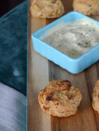 air fryer frozen crab cakes on wood board with sauce