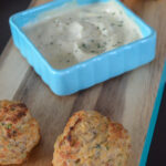 air fryer frozen crab cakes on serving board with aoili in bowl