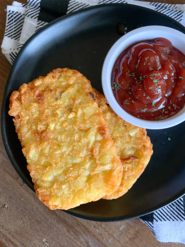 overhead photo of air fryer hash brown patties with serving of ketchup