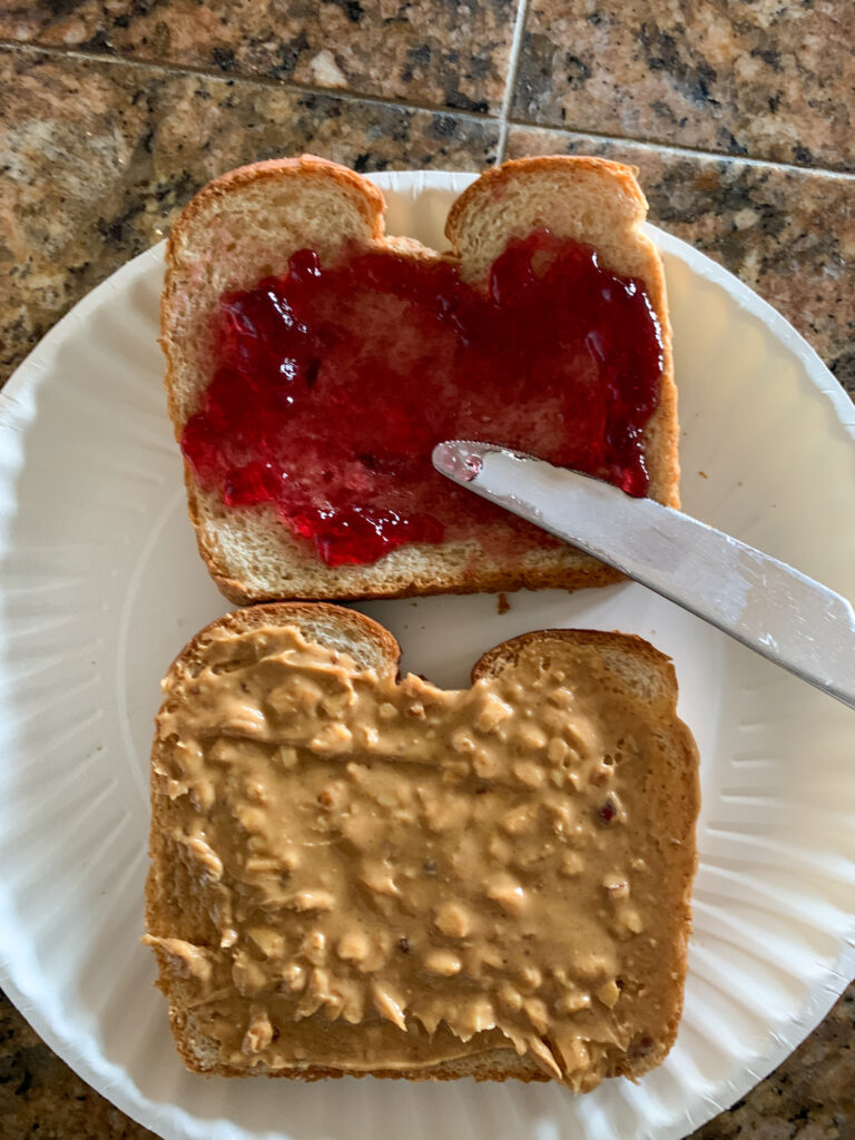 knife spreads jelly on bread