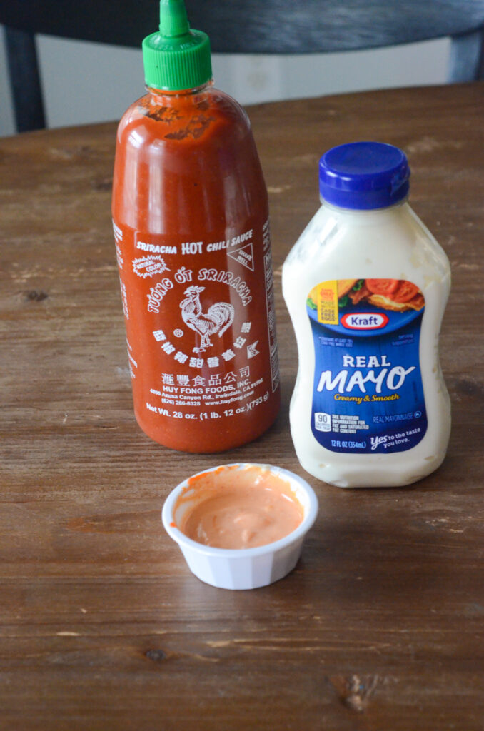 sriracha sauce and mayo bottles with bowl of sriracha mayo sauce on table