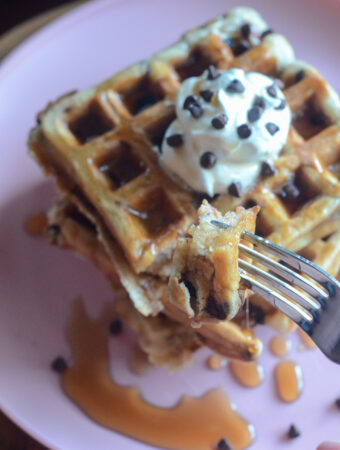 stack of waffles with chocolate chips on pink plate