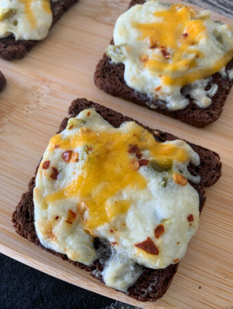 jalapeno artichoke dip rye bread appetizers on wooden tray