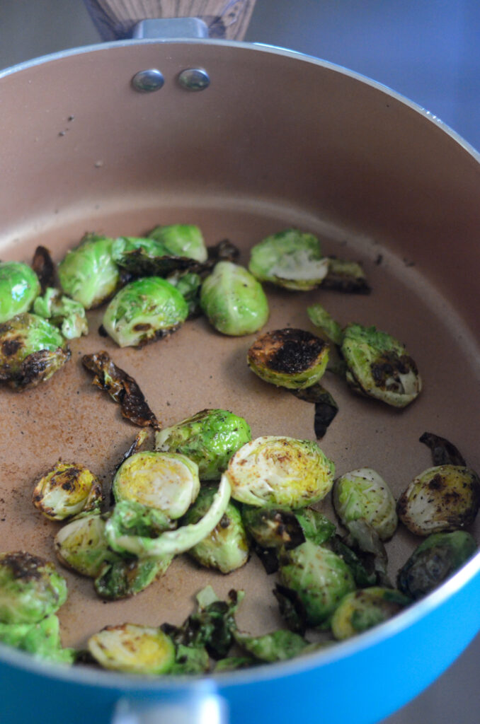 pan fried Brussels sprouts searing in blue skillet