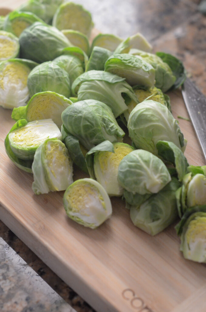 trimming Brussels sprouts on wooden cutting board