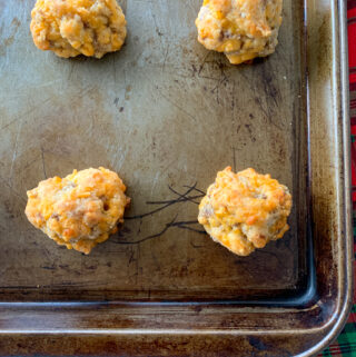 sausage balls with flour on brown cookie sheet