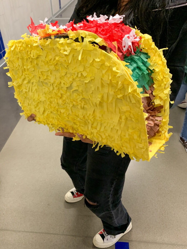 kid holds a giant taco pinata for Anything But a Backpack day for theme day