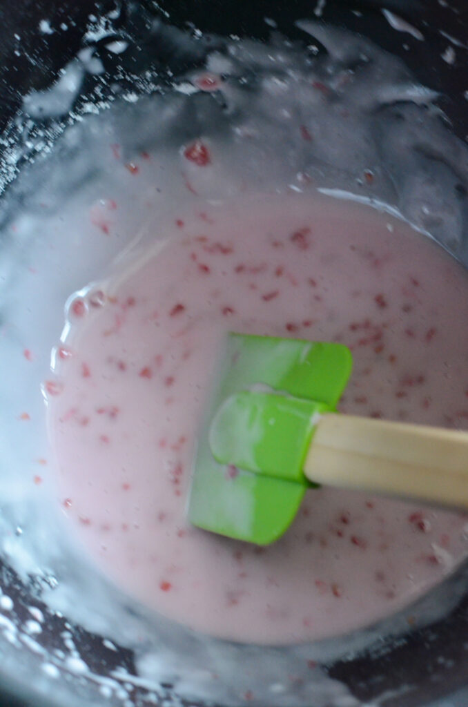 raspberry powdered sugar glaze being mixed in bowl