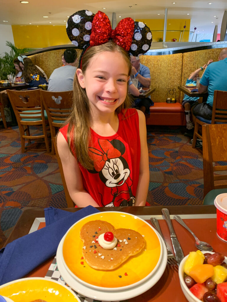 daughter of lifestyle blogger, Amy from Planted in Arkansas, smiles at Chef Mickey's Breakfast on a 7 day Disney World Itinerary