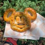 woman holds a Disney World Mickey Mouse pretzel at Hollywood Studios